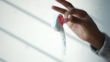 mano con una cuchara medidora con detergente para la ropa