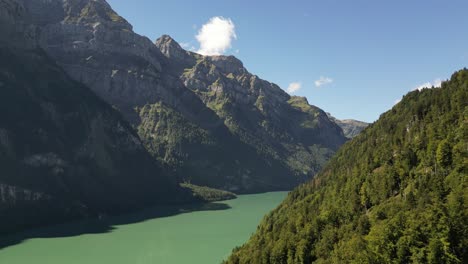 Majestic-Peaks,-Crystal-Waters:-Aerial-view-of-green-forest-and-Lakeside-Mountains