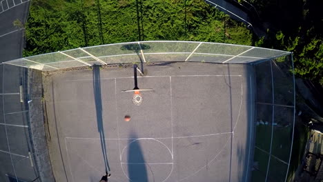 a birds eye aerial over a basketball player shooting a jump shot on an outdoor court 1