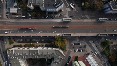 Ojo-De-Pájaro-Aéreo-Vista-Panorámica-De-Arriba-Hacia-Abajo-Del-Transporte-En-La-Ciudad.-Un-Par-De-Tranvías-Que-Pasan-Uno-Junto-Al-Otro-En-Una-Carretera-Elevada-Con-Vías-De-Tranvía.-Varsovia,-Polonia