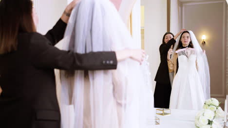 asian and caucasian woman in wedding dress shop