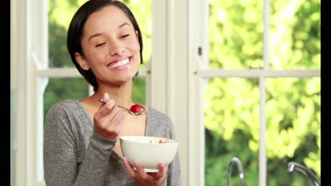 Woman-eating-cereal-in-kitchen