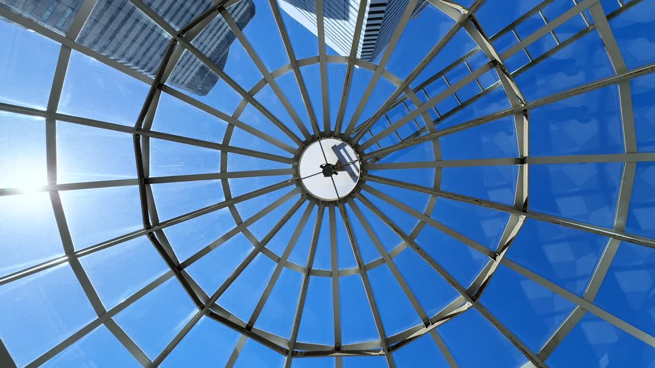 A modern glass dome structure with a glimpse of skyscrapers in tokyo, aerial view