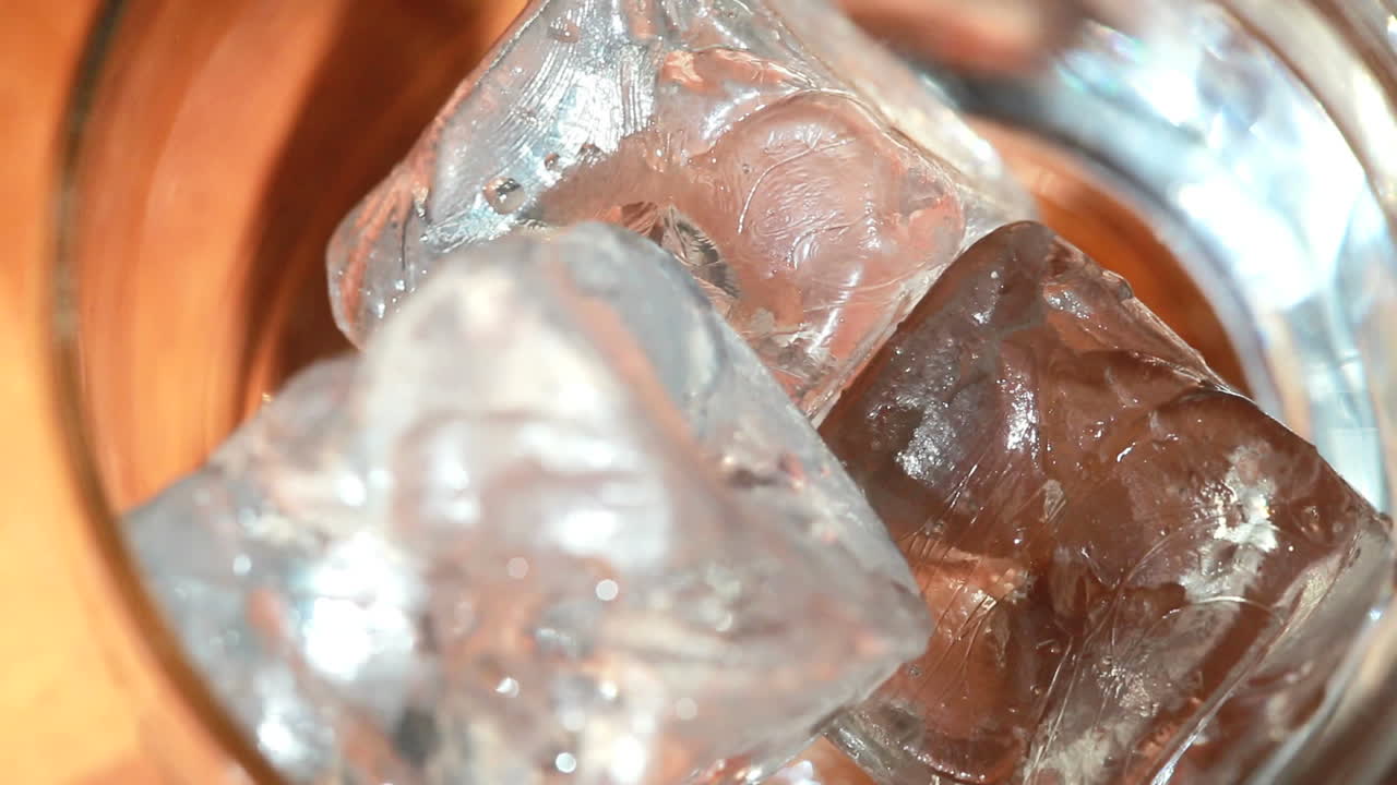 encima del vaso de llenado de hielo y whisky