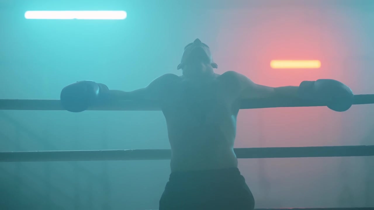 Silhouette of Boxer Resting in Ring with Dramatic Lighting