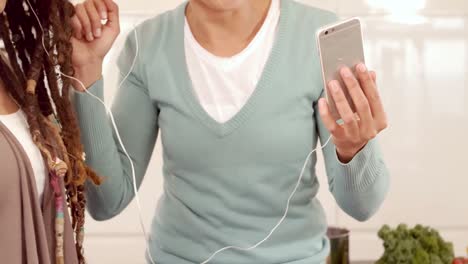 Lesbian-couple-using-smartphone-and-headphones-together