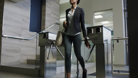 african american businesswomen walking through a turnstile entering an office in slow motion