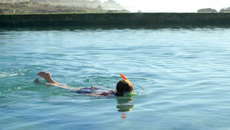 Frau-Schwimmt-Im-Wasser-Am-Strand-4k