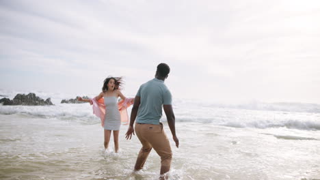 couple playing in the ocean on a sunny day