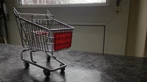Mini-empty-shopping-cart-online-home-supermarket-concept-copy-space-closeup-slow-reverse-dolly-right