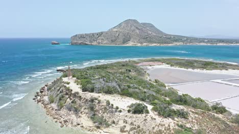 aerial view of small islet - isla cabra lighthouse structure and salt pans