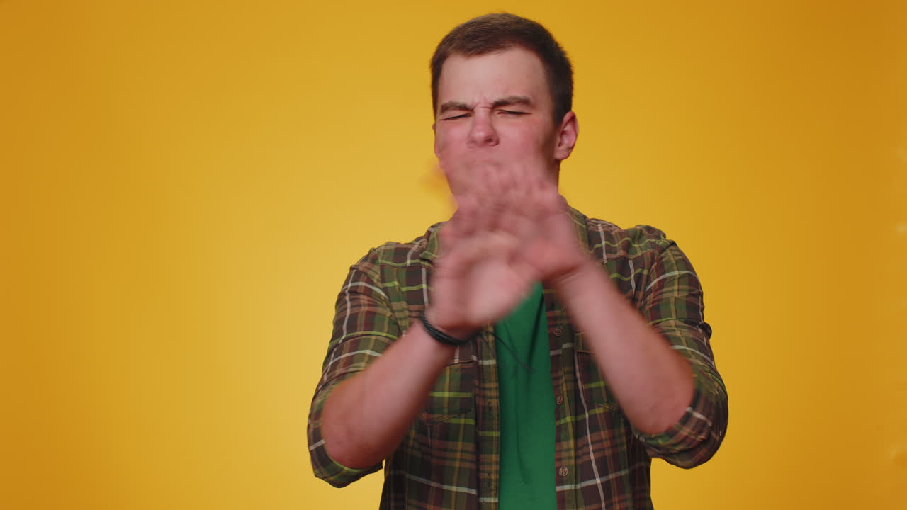 hombre adulto joven conmocionado cerrando los ojos con la mano mostrando el gesto de parada, confundido tímido asustado de ver