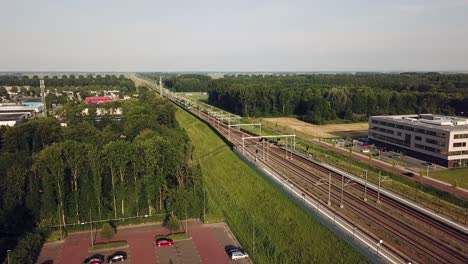 Drone-view-of-a-train-arriving-in-Dronten,-Flevoland,-The-Netherlands
