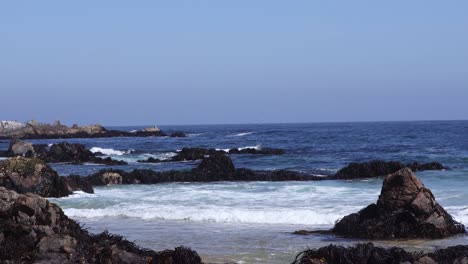 En-La-Playa-De-Guijarros,-Las-Incesantes-Olas-Rompían-Contra-Las-Rocas,-Creando-Una-Fascinante-Sinfonía-De-Sonido-Y-Rocío