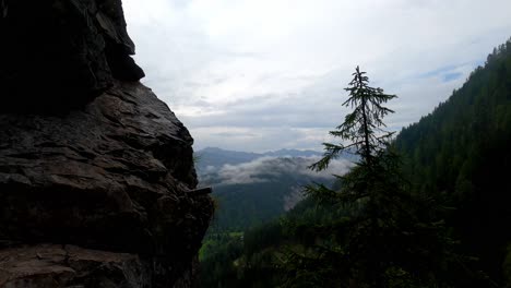 a view from above into a cloudy valley full of trees