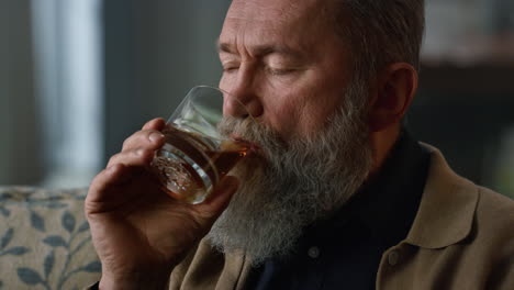 portrait thoughtful senior man drinking whiskey. wealth retirement life concept