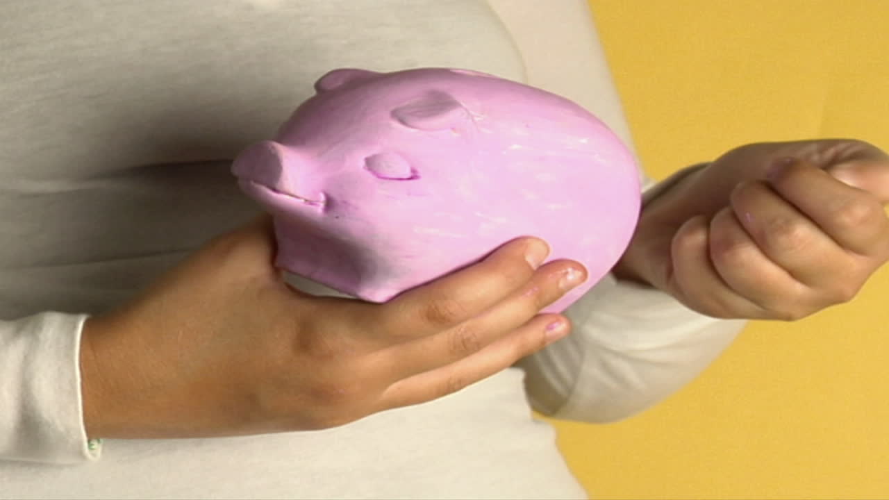 una mujer coloca monedas en una alcancía