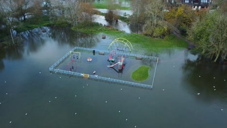 children playground and recreational park flooded by winter storm in england