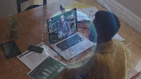 animation of globe of connections over woman using laptop on video call in background