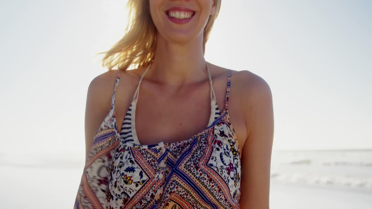 mujer de pie con su bicicleta en la playa
