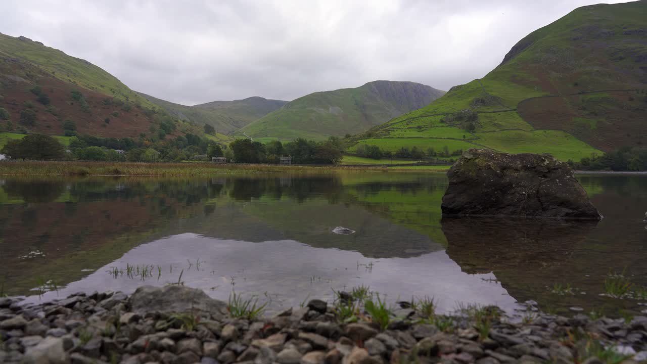disparo bajo del control deslizante del lago de agua placid brothers en un día nublado, lake district, cumbria, inglaterra