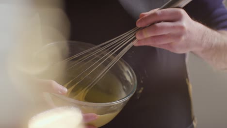 gros plan sur un homme dans la cuisine à la maison en fouettant les ingrédients dans un bol pour faire cuire le gâteau 4