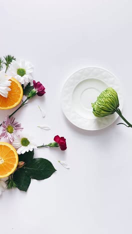 floral arrangement with oranges and plate