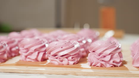 multiple swirl pink cupcakes arranged neatly on brown baking paper with slight blur in background, showcasing texture, detail, and soft lighting in cozy kitchen atmosphere ready for baking or display