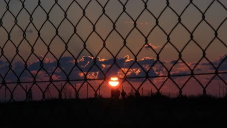 Weite-Sicht-Auf-Einen-Belebten-Fußweg-Mit-Menschen,-Die-Am-Späten-Abend-Unter-Einem-Wunderschönen-Sonnenuntergang-Spazieren-Gehen-Und-Joggen