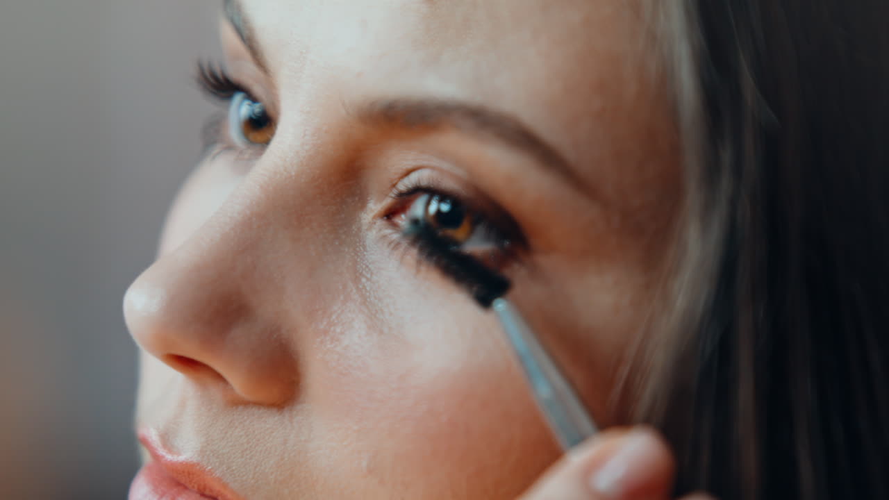 Woman making eyelashes makeup at morning home routine closeup. Portrait brunette