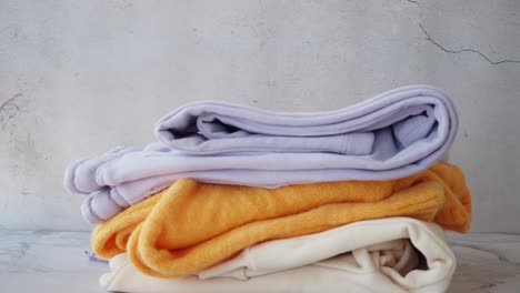 stack of folded sweaters in pastel colors