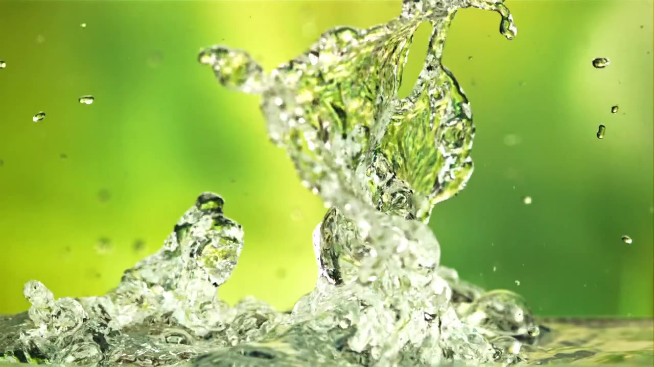 Spruzzo d'acqua rinfrescante e goccioline su sfondo verde vibrante