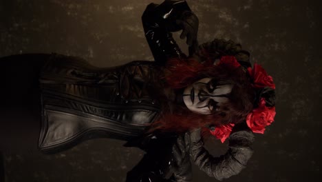 catrina cosplay girl moving closer to the camera with a domina outfit and dark background , medium close up