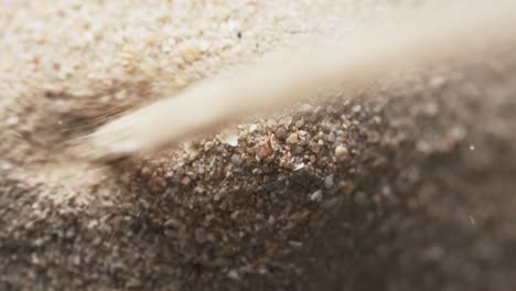 Video-of-close-up-of-sand-grains-pouring-into-heap-and-copy-space-background