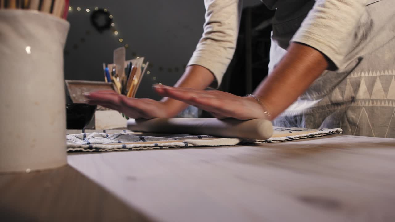 스튜디오 에서 도자기 - 롤링 핀 을 사용 하여 점토 를 평평 하게 하는 젊은 여자