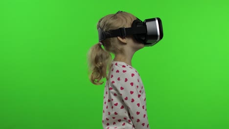 child girl using vr headset helmet to play game. watching virtual reality 3d 360 video. chroma key