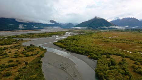 Panoramic-aerial-dolly-above-meandering-curves-in-river-of-lowlands-of-Glenorchy