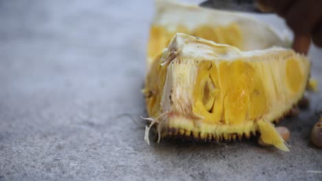 Hand-held-slow-motion-shot-of-an-Indonesian-man-cutting-into-a-Jack-fruit