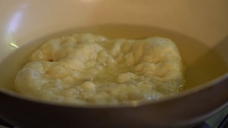 Close-up-Langos-bread-cooked-in-oil-in-pan-in-home-kitchen