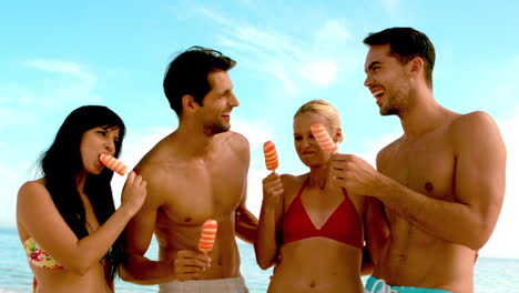 Amigos-Riendo-Y-Comiendo-Helado-En-La-Playa