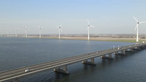 flyover along ketelbrug bridge over lake, windmills in lake shore