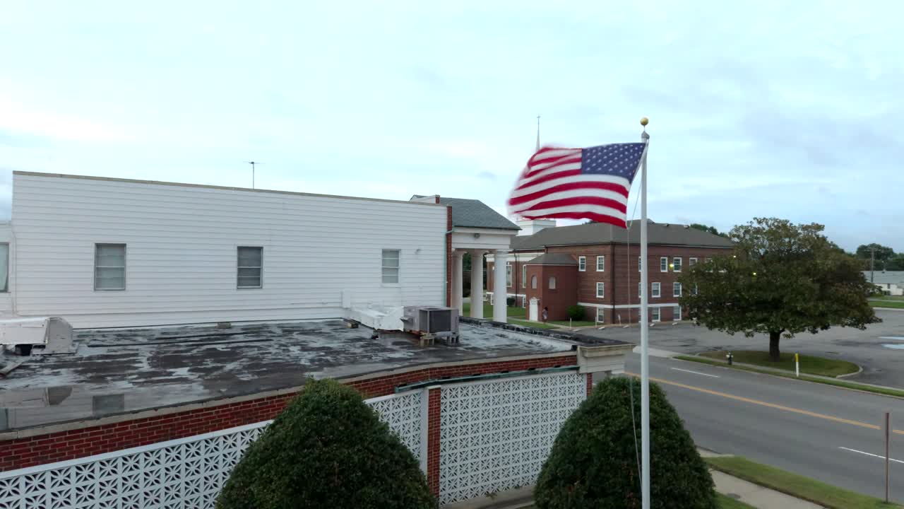 American Flag blowing in the wind. Heavy wind gusts from the outer edge of hurricane Florence in Virginia with clouds in a beautiful sky.