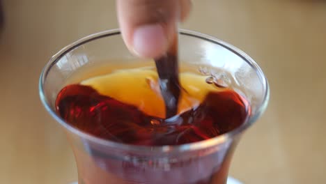 stirring a glass of turkish tea