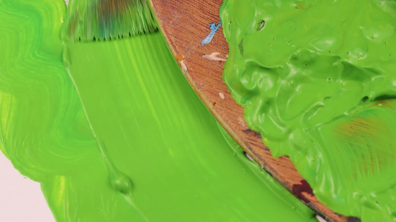 tiro pintando un papel verde al lado de la paleta