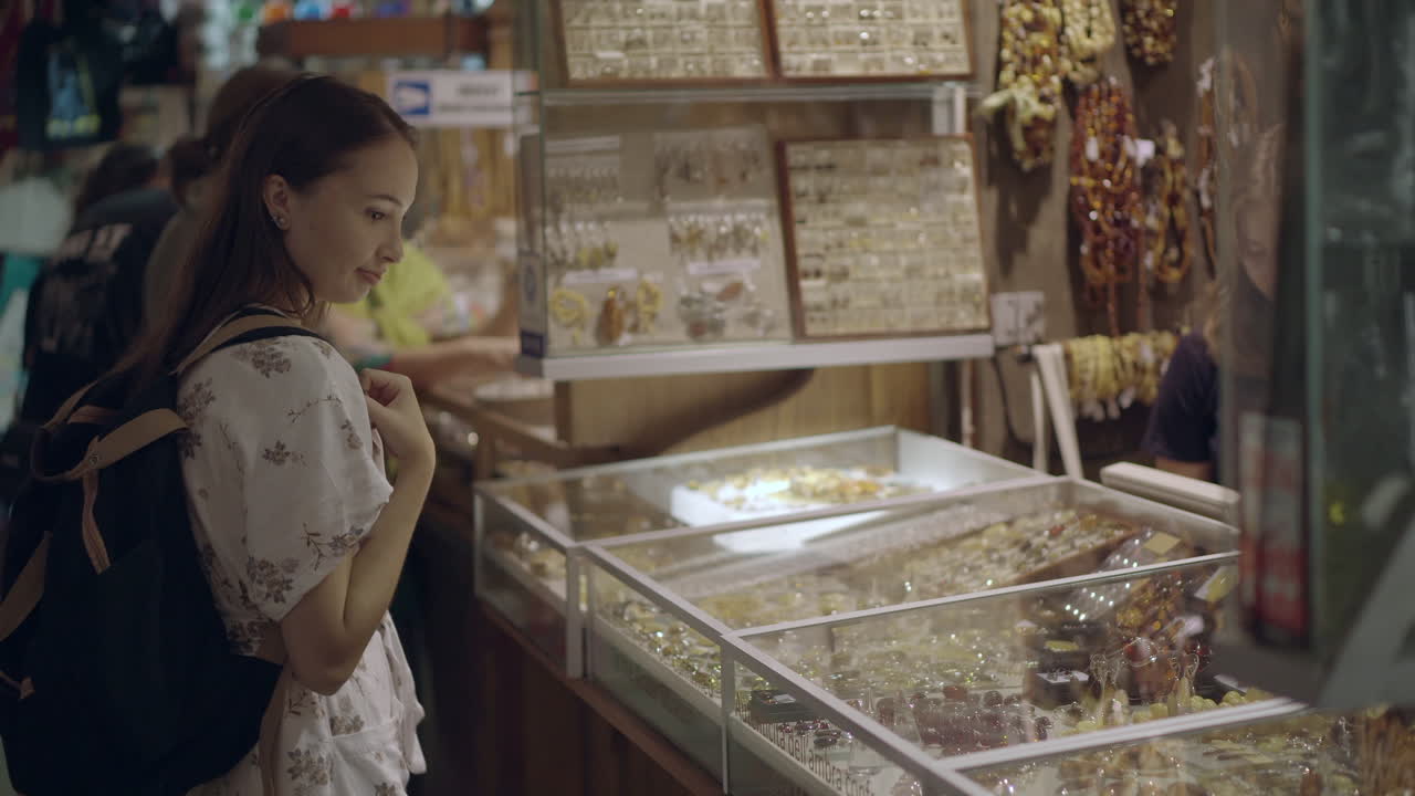 시장 에서 암버 보석 을 검색 하는 여자