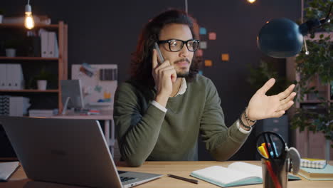 Man having a phone call in a modern office at night