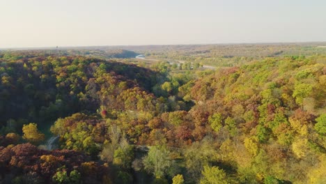 Higher-flyover-of-autumnal-forest-and-hills-at-Ledges-State-Park