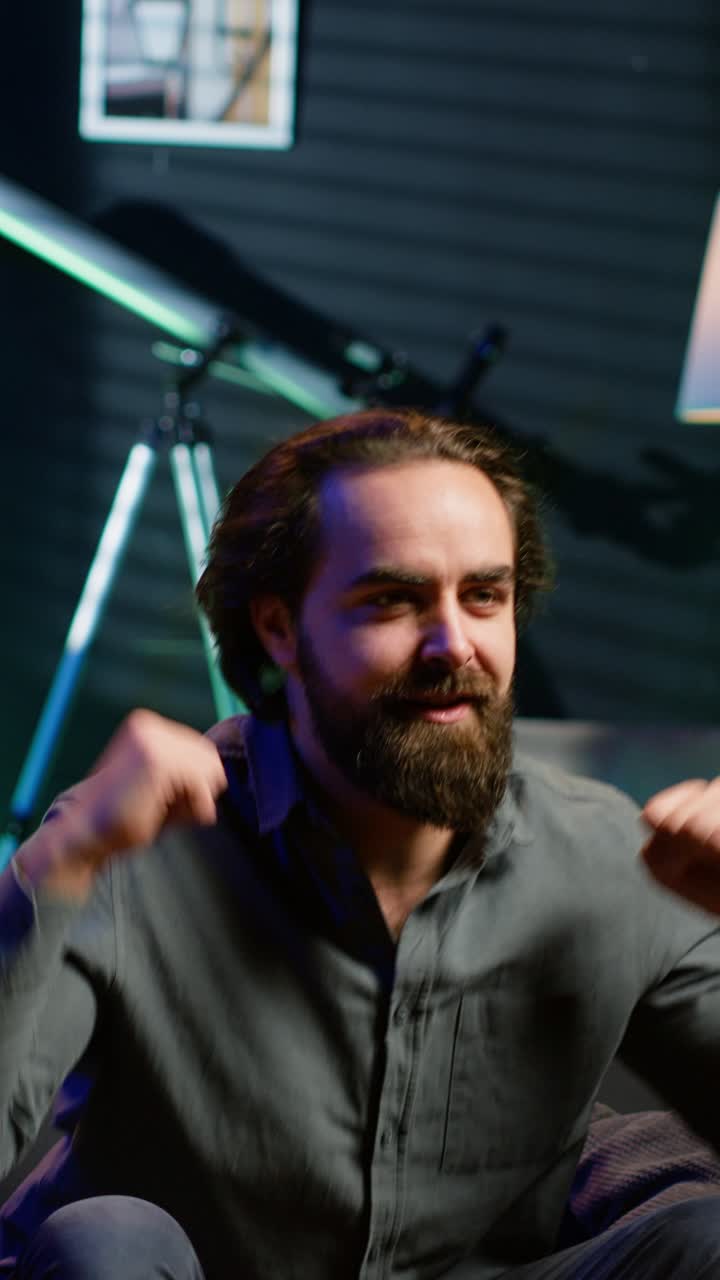 Vertical video Ecstatic man watching sports broadcast at home, doing frantic hand gesturing
