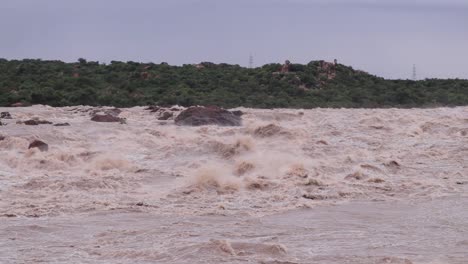 Pan-view-of-Heavy-floodwater-entering-into-the-village-through-the-mountains-in-North-Karnataka,-India