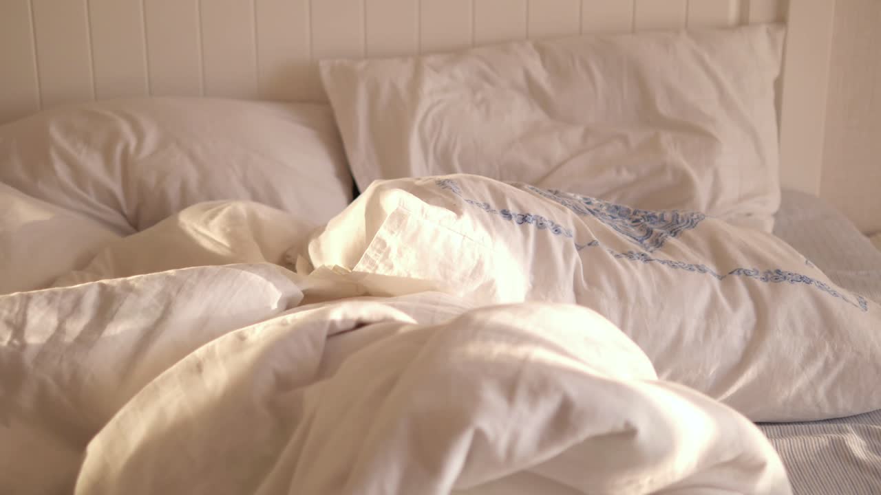cama sin hacer en un dormitorio soleado